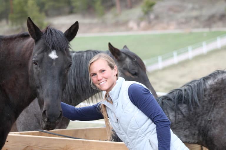 Staff member with horses at Renewing Hope Ranch in a rural setting.
