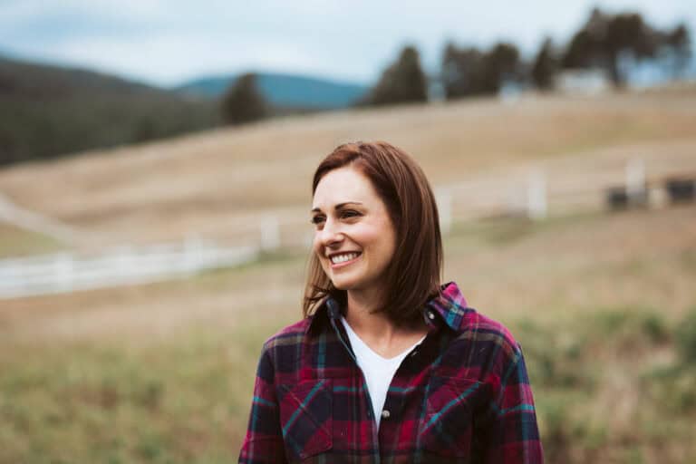 Smiling woman at Renewing Hope Ranch in outdoor setting.